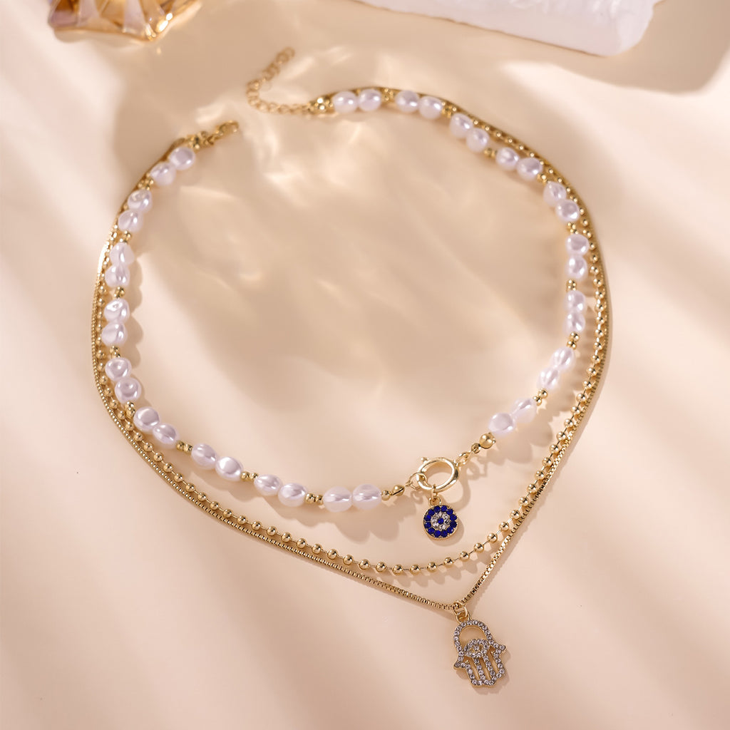 Elegant Layered Pearl Necklace with Evil Eye & Hamsa Charm – Chic and Protective